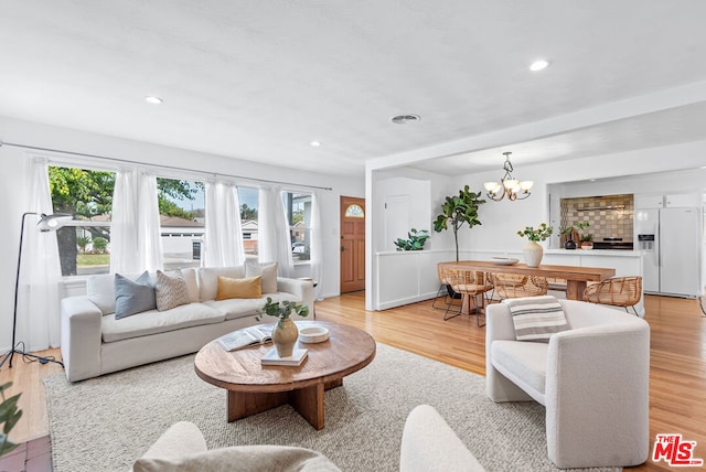 living room with light hardwood / wood-style floors and a chandelier