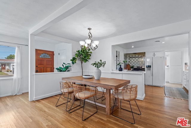 dining room with an inviting chandelier and light hardwood / wood-style flooring