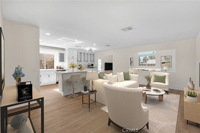 living room with light wood-type flooring and plenty of natural light