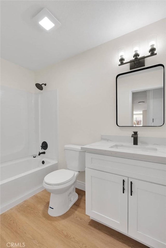 full bathroom featuring wood-type flooring, toilet, bathtub / shower combination, and vanity