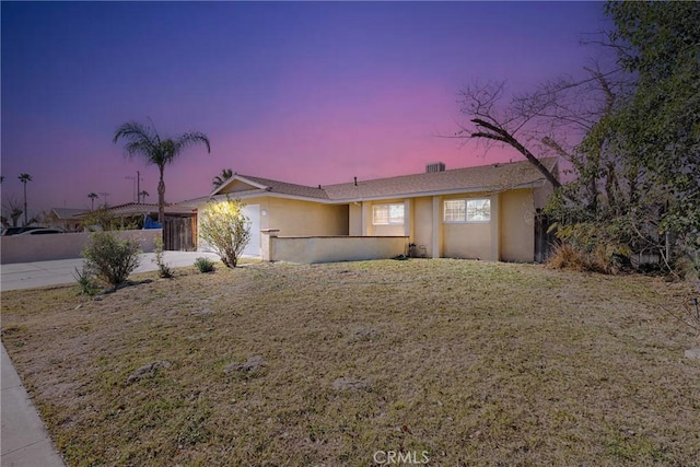 ranch-style home with a lawn