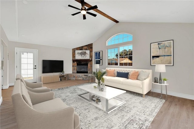 living room with a fireplace, hardwood / wood-style floors, a wealth of natural light, and vaulted ceiling with beams