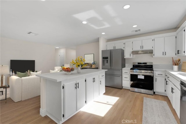 kitchen featuring light hardwood / wood-style floors, white cabinets, appliances with stainless steel finishes, and a center island