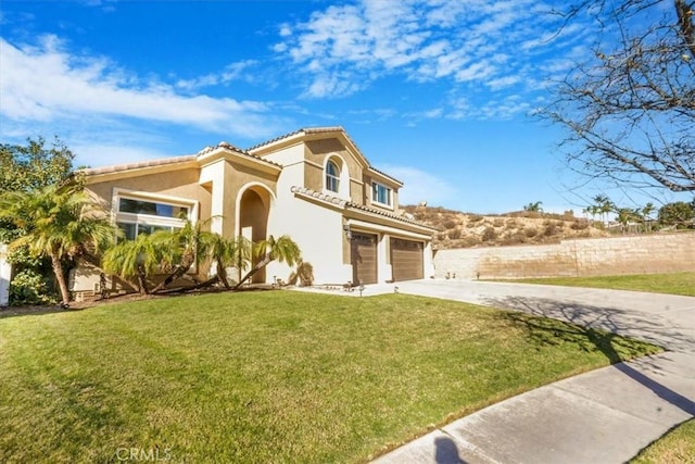 mediterranean / spanish house with a garage and a front yard