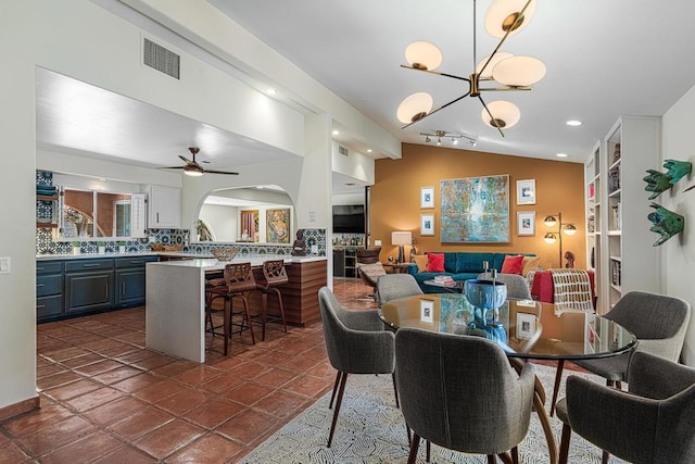 tiled dining room with vaulted ceiling, ceiling fan with notable chandelier, and built in shelves