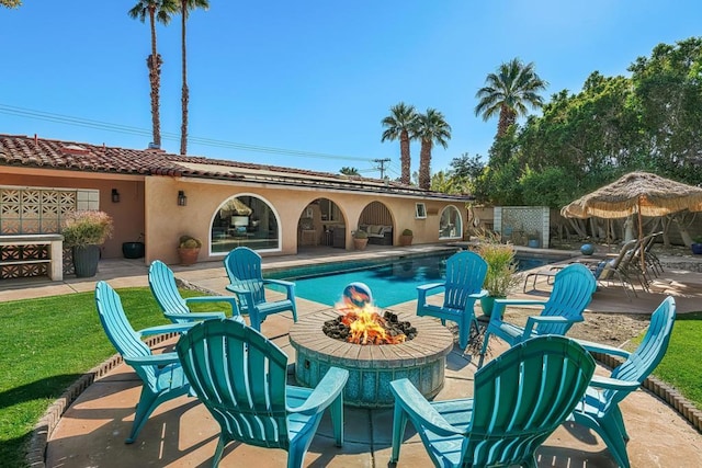 view of swimming pool with a fire pit and a patio