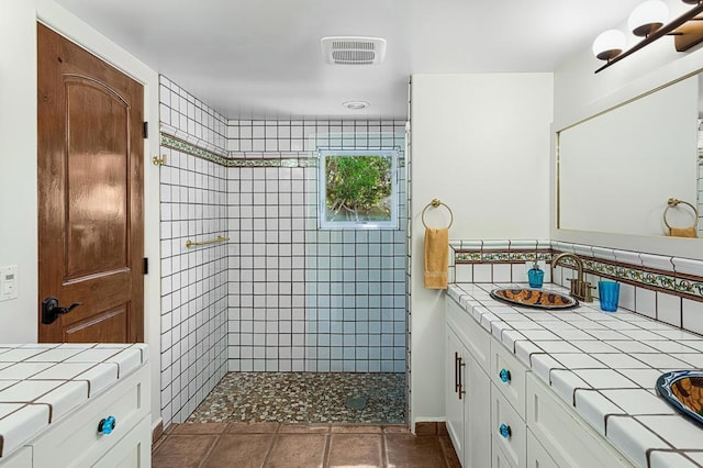 bathroom featuring a tile shower, vanity, and tasteful backsplash