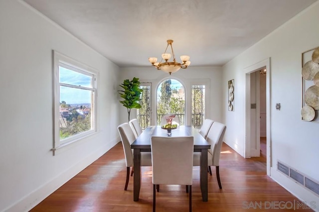 dining area featuring an inviting chandelier and dark hardwood / wood-style floors