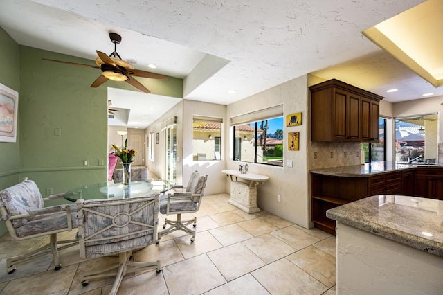 kitchen with ceiling fan, light tile patterned floors, and tasteful backsplash