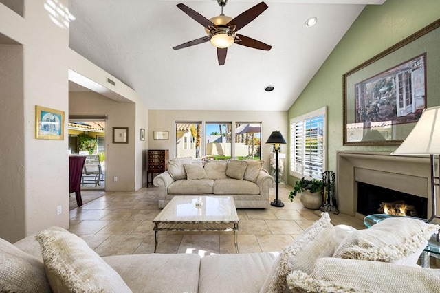 living room with ceiling fan, lofted ceiling, and light tile patterned flooring