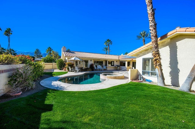 view of swimming pool featuring an in ground hot tub, a patio area, and a lawn