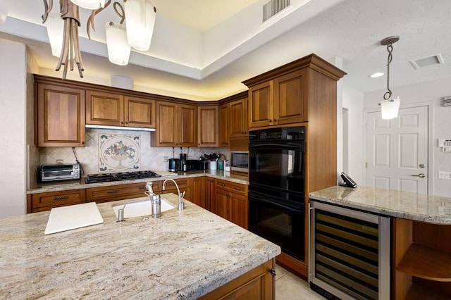 kitchen featuring beverage cooler, decorative light fixtures, double oven, tasteful backsplash, and sink