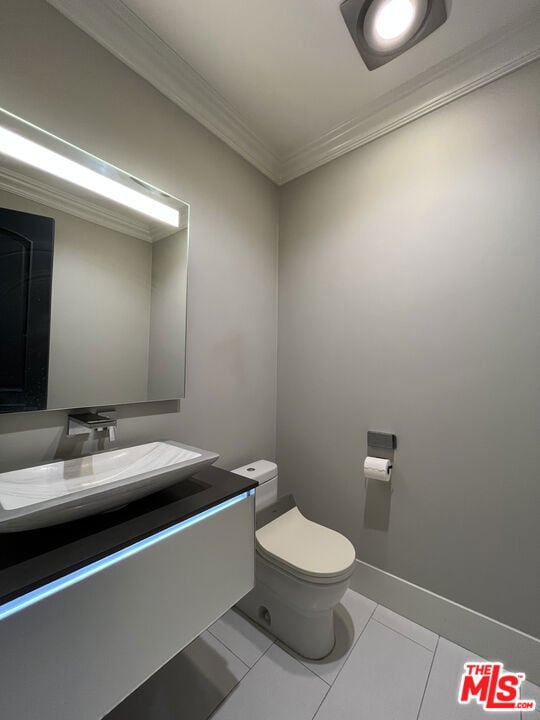 bathroom featuring tile patterned floors, vanity, ornamental molding, and toilet