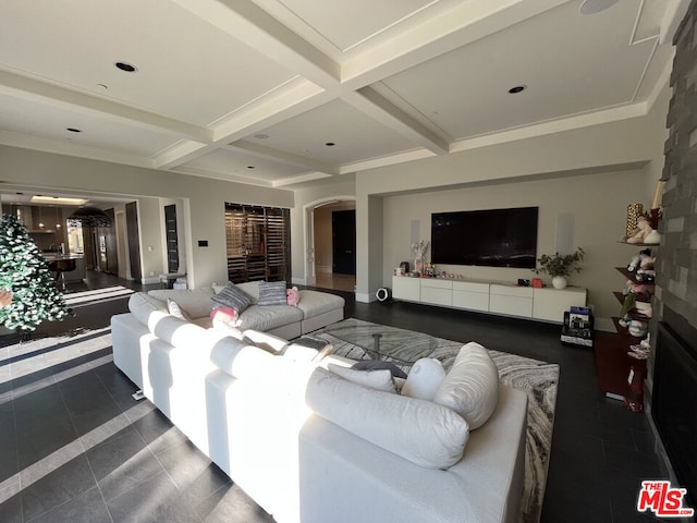 living room featuring coffered ceiling, beamed ceiling, and dark tile patterned floors