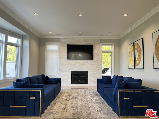 living room with crown molding, plenty of natural light, and a stone fireplace