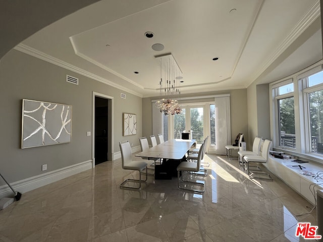 dining room featuring a notable chandelier, a tray ceiling, and ornamental molding