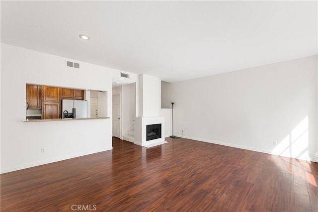 unfurnished living room with dark hardwood / wood-style flooring