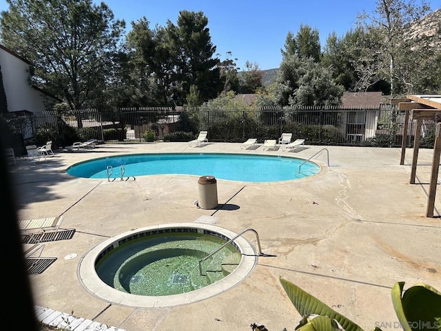 view of pool featuring a patio area and a community hot tub