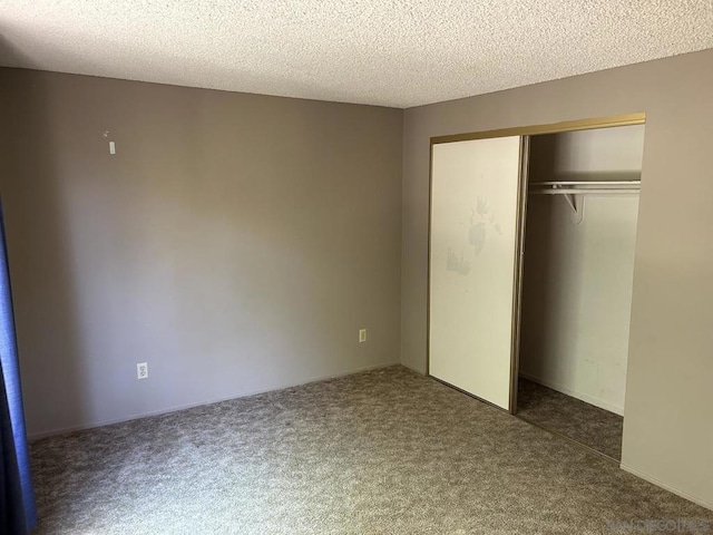 unfurnished bedroom with a textured ceiling, a closet, and dark carpet