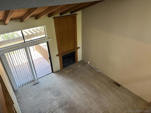 unfurnished living room featuring carpet, wooden ceiling, and lofted ceiling with beams