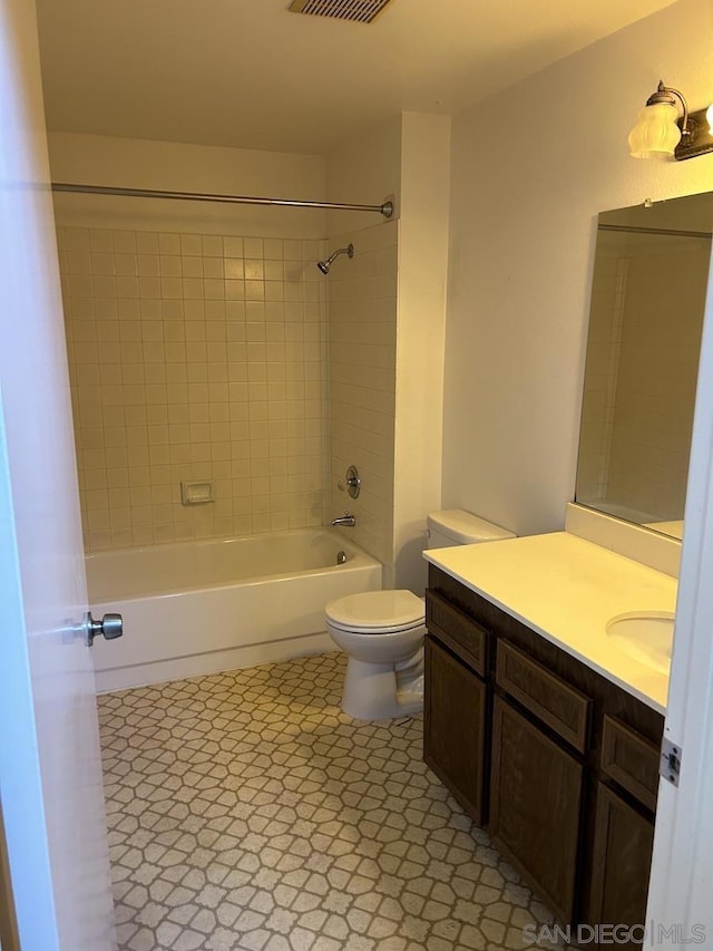 full bathroom with toilet, tiled shower / bath, and vanity