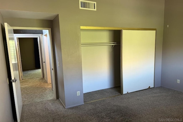 unfurnished bedroom featuring a closet and dark colored carpet