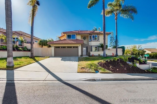 mediterranean / spanish house featuring a garage and a front lawn