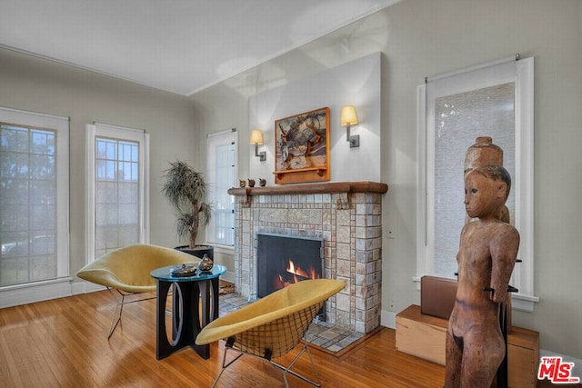 sitting room with a tile fireplace and hardwood / wood-style floors