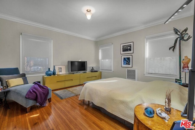 bedroom featuring light hardwood / wood-style floors and ornamental molding