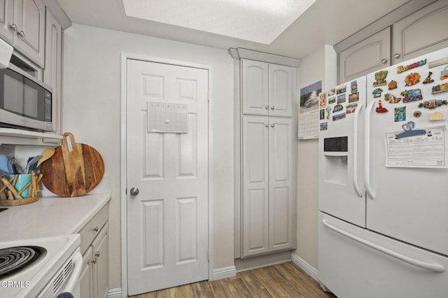 kitchen featuring gray cabinets, dark hardwood / wood-style floors, and white refrigerator with ice dispenser