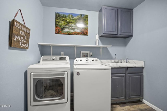 laundry area featuring cabinets, sink, dark hardwood / wood-style flooring, and washing machine and dryer