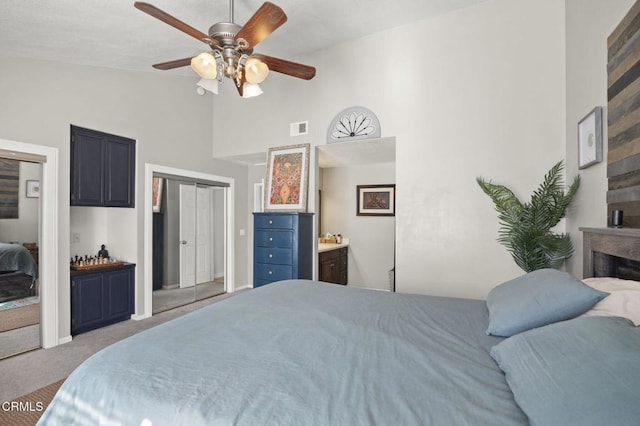 carpeted bedroom with ceiling fan, ensuite bath, and lofted ceiling