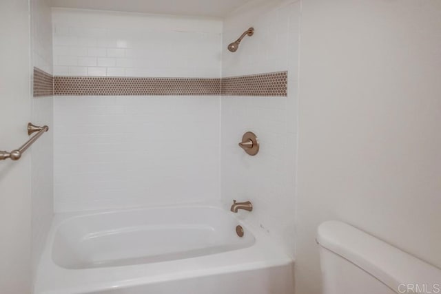 bathroom featuring toilet and tiled shower / bath