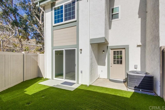 back of house with a yard and central air condition unit