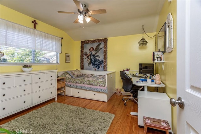 bedroom with ceiling fan, light hardwood / wood-style flooring, and lofted ceiling