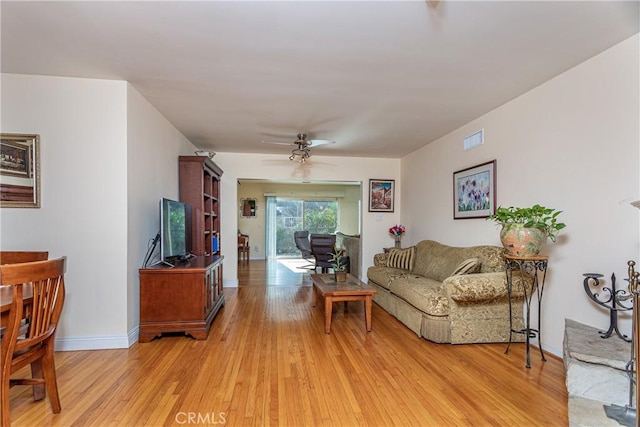 living room with light wood-type flooring and ceiling fan