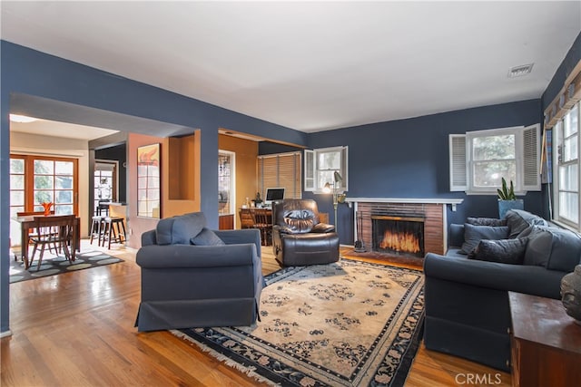 living room featuring wood-type flooring and a fireplace