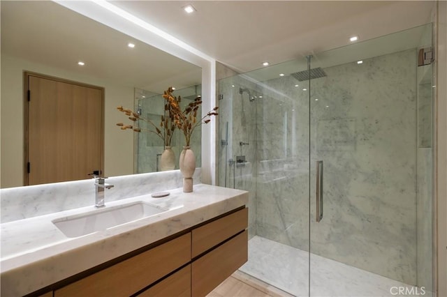 bathroom with a shower with door and vanity