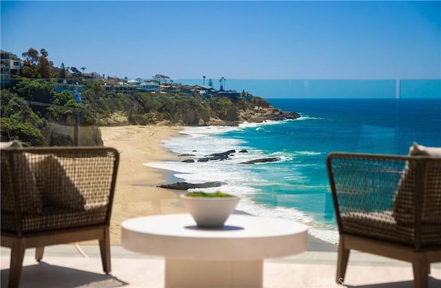 balcony featuring a beach view and a water view