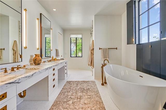 bathroom with a bath, tile patterned floors, and vanity