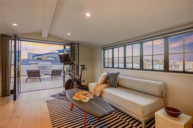 interior space featuring light hardwood / wood-style floors and vaulted ceiling with beams