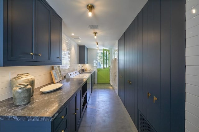 kitchen featuring sink, blue cabinetry, concrete flooring, and electric range oven