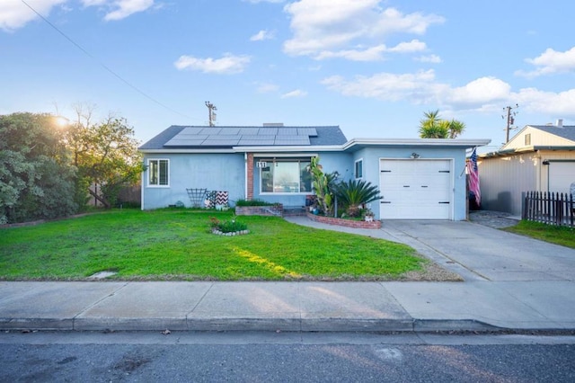 ranch-style home with a garage, a front lawn, and solar panels