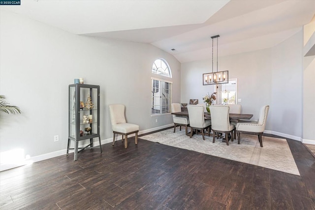 dining area with wood-type flooring, a chandelier, and vaulted ceiling