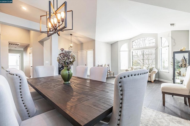 dining space featuring hardwood / wood-style flooring, vaulted ceiling, and a chandelier