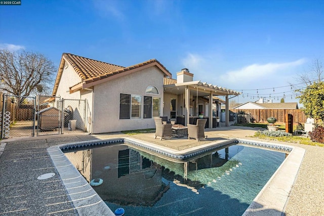 back of house featuring a fenced in pool and a patio area