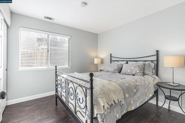 bedroom with dark hardwood / wood-style flooring