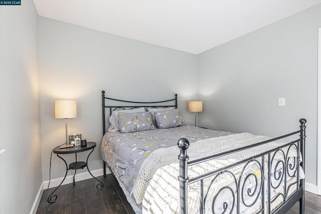 bedroom with dark hardwood / wood-style floors