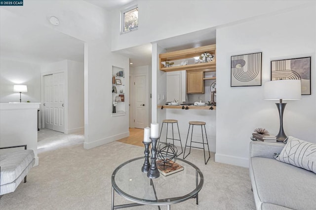 living room with a high ceiling and light colored carpet