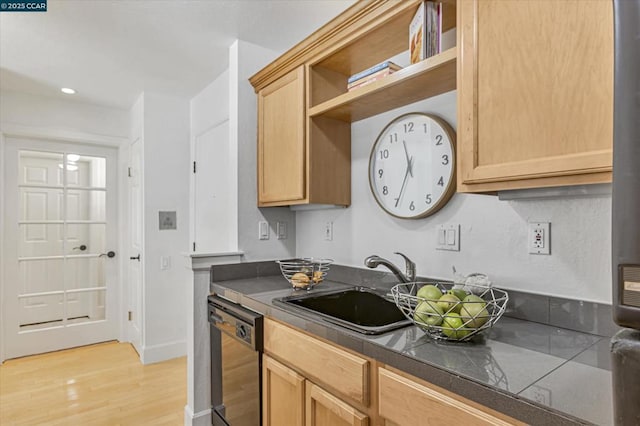 kitchen with sink, stainless steel dishwasher, light brown cabinetry, and light hardwood / wood-style floors